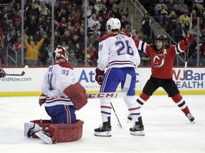 Devils' Taylor Hall celebrates after scoring, while defenceman Jeff Petry and goalie Carey Price look on in frustration Wednesday night in Newark, N.J.