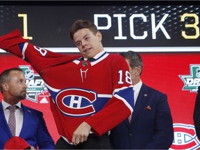 Finland’s Jesperi Kotkaniemi puts on a Canadiens sweater after being selected with the No. 3 overall pick at the NHL Draft in Dallas on June 22, 2018.