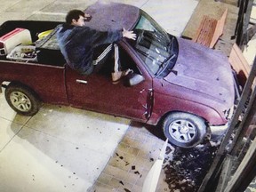 In this image taken from Harrison County surveillance video, released by the Harrison County Board of Supervisors, Keith Cavalier is seen climbing out of a Toyota Tacoma truck after it hit the east side of the courthouse in Gulfport, Miss., Saturday morning, Nov. 10, 2018. Cavalier, of Gulfport, was arrested in the incident on charges of driving under the influence and felony malicious mischief. (Harrison County Board of Supervisors via the AP) ORG XMIT: MSRS101