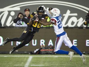 Hamilton Tiger-Cats wide receiver Bralon Addison (86) grimaces as he's hit by Montreal Alouettes defensive back T. J. Heath (24) after making a catch in Hamilton on Saturday, Nov. 3, 2018.