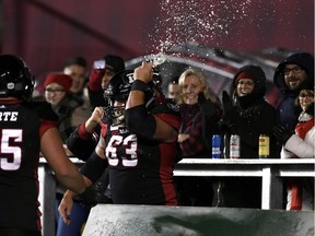 Ottawa Redblacks offensive lineman Jon Gott (63) smashes a beer can on his helmet, celebrating his team's touchdown against the Toronto Argonauts on Friday, Nov. 2, 2018.