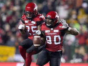 Calgary Stampeders defensive lineman Folarin Orimolade (90) and running back Don Jackson (25) celebrate against the Ottawa Redblacks during the first half of the 106th Grey Cup in Edmonton on Sunday, Nov. 25, 2018.