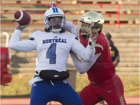 Montreal Carabins' Samuel Caron gets tackled by Laval Rouge et Or's Mathieu Betts during first half of the Dunsmore Cup on Nov. 11, 2017, in Quebec City.