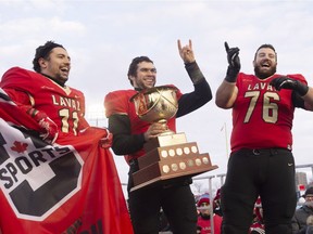 Laval Rouge et Or players Benoît Gagnon-Brousseau, from the left, Hugo Richard and Samuel Thomassin celebrate their victory against St. Francis Xavier X-Men at the Uteck Bowl on Saturday, Nov. 17, 2018, at Laval University in Quebec City. Laval defeated St. Francis Xavier 63-0.
