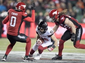 Calgary Stampeders defensive back Ciante Evans (0) and Stampeders linebacker Alex Singleton (49) try and stop Ottawa Redblacks wide receiver Brad Sinopoli (88) during the second half of the 106th Grey Cup in Edmonton, Alta. Sunday, Nov. 25, 2018.