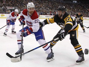 Montreal Canadiens' Karl Alzner pokes the puck off the stick of Pittsburgh Penguins' Bryan Rust during the second period in Pittsburgh on March 31, 2018.