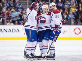 Canadiens' Phillip Danault, from left to right, Jonathan Drouin and Jeff Petry celebrate Drouin's goal during third period NHL hockey action against the Canucks in Vancouver on Saturday, Nov. 17, 2018.