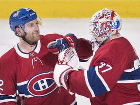 Montreal Canadiens goaltender Antti Niemi celebrates with teammate Karl Alzner, left, after defeating the New York Islanders in Montreal on Feb. 28, 2018.