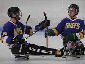 Humboldt Broncos hockey player Jacob Wassermann, left, and teammate Ryan Straschnitzki compare sticks during a sled hockey scrimmage at the Edge Ice Arena in Littleton, Colo., on Friday, Nov. 23, 2018. Jacob Wassermann says there have been some unexpected side effects following months of physio after being paralyzed from the navel down in the Humboldt Broncos bus crash.