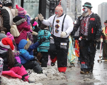 Clowns check in with parade watchers on Saturday, Nov. 17, 2018, during the annual Santa Claus Parade down Ste-Catherine St. in Montreal.