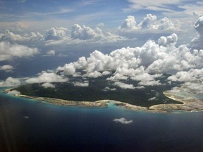 FILE – In this Nov. 14, 2005 file photo, clouds hang over the North Sentinel Island, in India's southeastern Andaman and Nicobar Islands. India used heat sensors on flights over hundreds of uninhabited Andaman Sea islands Friday, March 14, 2014, and will expand its search for the missing Malaysia Airlines jet farther west into the Bay of Bengal, officials said. The Indian-controlled archipelago that stretches south of Myanmar contains 572 islands covering an area of 720-by-52 kilometers. Only 37 are inhabited, with the rest covered in dense forests.