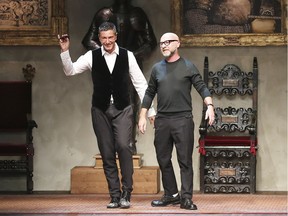 In this Jan. 11, 2014 file photo Italian fashion designers Domenico Dolce, right, and Stefano Gabbana acknowledge the applause of the audience after a men's Autumn-Winter 2014 collection, part of the Milan Fashion Week, unveiled in Milan, Italy. The designers have defended Sunday, March 15, 2015 their comments in support of traditional families, saying they were not intended to judge the choices made by others. The comments in an interview this week unleashed a call to boycott the designers' Dolce&Gabbana label, joined by Elton John whose children were conceived by in vitro fertilization.