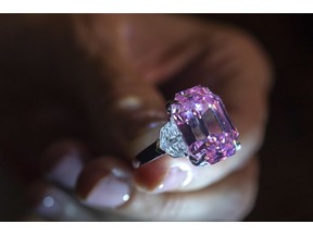 FILE - In this Thursday, Nov. 8, 2018 file photo, a Christie's employee displays an 18.96-carat fancy vivid pink diamond during a preview at Christie's in Geneva, Switzerland. Christie's sold the "Pink Legacy" diamond at auction Tuesday, Nov. 13 for more than $50 million including fees, saying it's a new world record price per carat for a pink diamond. Christie's said that renowned jeweler Harry Winston was the buyer.