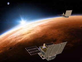 This illustration made available by NASA in March 2018 shows the twin Mars Cube One project (MarCO) spacecrafts flying over Mars with Earth and the sun in the distance. The MarCOs were the first CubeSats, a kind of modular, mini-satellite, flown into deep space. They were designed to fly along behind NASA's InSight lander on its cruise to Mars.