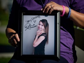 Carol Todd holds a photograph of her late daughter Amanda Todd signed by U.S. singer Demi Lovato. with the words "Stay Strong." Amanda committed suicide in 2012 after an online predator harassed her with a topless image he managed to extract from her.