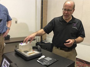 In this photo taken November 16, 2018, Stephen Meer, chief information officer from ANDE, demonstrates in Chico, Calif., his company's Rapid DNA analysis system, which is being used to try to ID victims of the Northern California wildfire. Authorities have deployed a powerful tool to aid in their race to identify the remains of 77 bodies burned in the deadly wildfire that ripped through Northern California: Rapid DNA testing that produces results in just two hours. But the technology that can match DNA to bone fragments in as little as two hours is only as effective as the numbers of people who show up to give a sample, and so far there are not nearly enough volunteers. (Sudhin Thanawala) ORG XMIT: FX204