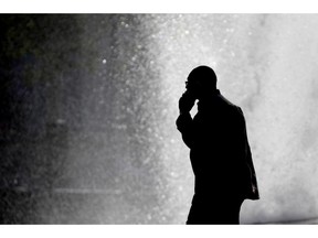 FILE - In this Thursday, Oct. 11, 2012 file photo, a pedestrian talking on a cellphone is silhouetted in front of a fountain in Philadelphia. Two U.S. government agencies are giving conflicting interpretations of a safety study on cellphone radiation: One says it causes cancer in rats. The other says there's no reason for people to worry.