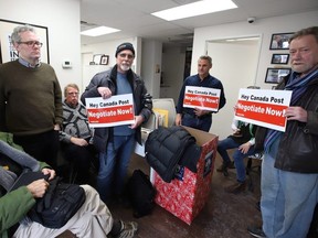 Members of the Canadian Union of Postal Workers occupy Minister of Environment Catherine McKenna's community office in Ottawa on Friday, Nov. 23, 2018.