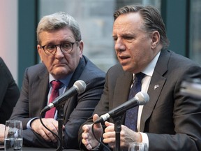 Quebec Premier Francois Legault responds to reporters questions at a news conference, Tuesday, November 6, 2018 in Quebec City. Quebec City mayor Regis Lebeaume, left, looks on.