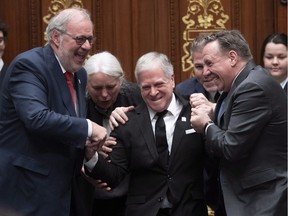 As per British custom, Quebec National Assembly Speaker François Paradis has to be forced to his seat by Quebec Premier François Legault, right; Liberal Leader Pierre Arcand, left; Québec Solidaire Leader Manon Massé, centre; and Parti Québécois interim Leader Pascal Bérubé on Tuesday.