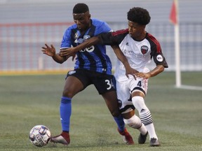 Montreal Impact's Clément Bayiha, left, tries to keep the ball from Ottawa Fury FC's Hansly Felix Malonga during exhibition game in Ottawa on Sept. 7, 2018.