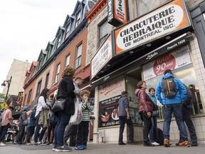 People line up outside of Schwartz's Delicatessen in Montreal on Sunday, Sept. 23, 2018.