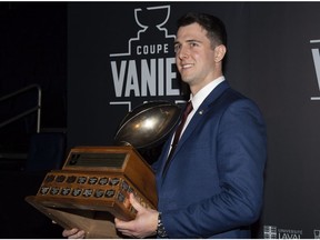 Calgary University Dinos quarterback Adam Sinagra receives the Hec Crighton trophy as outstanding player of the year, at the U SPORTS football gala as part of the Vanier Cup weekend, in Quebec City, Thursday, Nov. 22, 2018.