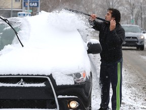 Zlatan Grigorov clears snow off his car in LaSalle Nov. 16, 2018.