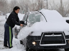 Zlatan Grigorov clears snow off his car in LaSalle Nov. 16, 2018.