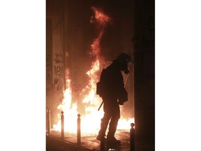 A riot policeman tries to avoid a petrol bomb during clashes in the Athens neighborhood of Exarchia, a haven for extreme leftists and anarchists, Saturday, Nov. 17, 2018. Clashes have broken out between police and anarchists in central Athens on the 45th anniversary of a student uprising against Greece's then-ruling military regime.