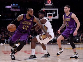 LeBron James #23 of the Los Angeles Lakers drives to the basket on Jrue Holiday #11 of the New Orleans Pelicans after a screen from Lonzo Ball #2 during a 112-104 Laker win at Staples Center on December 21, 2018 in Los Angeles, California.