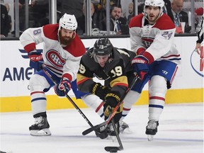 Reilly Smith  of the Vegas Golden Knights battles Canadiens' Jordie Benn, left, and Phillip Danault for the puck on Saturday, Dec. 22, 2018 in Las Vegas.