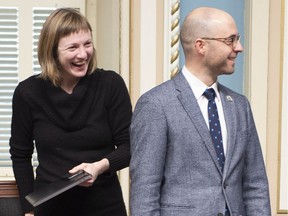 Quebec Solidaire MNAs Catherine Dorion, left, and Sol Zanetti smile as they enter for question period, Wednesday, December 5, 2018 at the legislature in Quebec City. Dorion's decision to wear a T-shirt on another occasion, to deliver her first speech in the Assembly, sparked controversy.