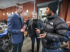 Matthew Pearce (centre), president and CEO of the Old Brewery Mission, and former director general James Hughes (left) speak with Kavy Edwards at the shelter's café in Montreal Tuesday Dec. 11, 2018.  Pearce and Hughes have collaborated on a book called Beyond Shelters.