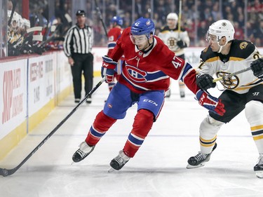 Kenny Agostino holds off John Moore of the Boston Bruins as he carries the puck in the Bruins end during first period Monday, Dec. 17, 2018.