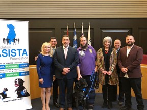 Pierrefonds-Roxboro Mayor Jim Beis, third from left, stands with Craig Read and service dog Joey, along with members of council and representatives from the Asista service-dog foundation.