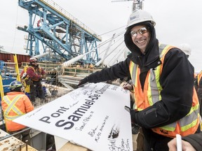 Bridge worker Sylvain Boivin displays the sign used during Wednesday's naming ceremony. The sign bears the signatures of fellow workers.