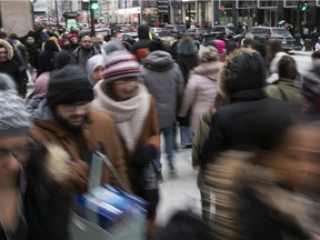 People walk along Ste-Catherine St. in downtown Montreal on Wednesday Dec. 26, 2018 as they rush about to get to Boxing Day sales.