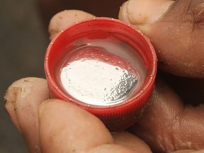 A gold miner displays mercury which will be used to help extract gold along the Madre de Dios River in the Amazon lowlands on November 14, 2013 near Puerto Maldonado, Peru.