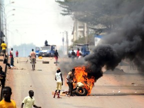 Protesters stand by burning tires during clashes with Guinea's police at the end of a demonstration on April 25, 2013 in Conakry.
