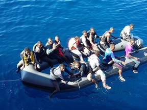This handout image released on October 30, 2015 by the Spanish Salvamento Maritimo (Coast Guard) shows 15 migrants sitting on the inflatable tubes of a pneumatic boat missing its hull off the coast of Spain prior to being rescued by the Spanish coast guard vessel Polimnia. Searches resumed this morning off Spainish coast to find 35 migrants missing since October 28 after trying to cross from Morocco aboard a boat that lost its bottom.  RESTRICTED TO EDITORIAL USE - MANDATORY CREDIT "AFP PHOTO/ SALVAMENTO MARITIMO " - NO MARKETING NO ADVERTISING CAMPAIGNS - DISTRIBUTED AS A SERVICE TO CLIENTS   -  AFP PHOTO/ HO/ SPANISH INTERIOR MINISTRYHO/AFP/Getty Images