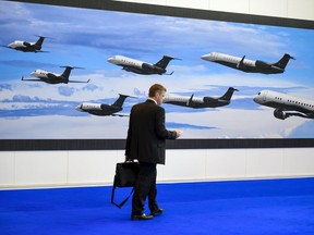 A visitor walks past the stand of Brazilian plane maker Embraer during the European Business Aviation Convention & Exhibition (EBACE) on May 24, 2016 in Geneva.