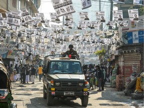 Bangladeshi army personnel drive a military vehicle through a street adorned with election posters near a polling station in Dhaka on December 30, 2018. - Bangladesh headed to the polls on December 30 following a weeks-long campaign that was dominated by deadly violence and allegations of a crackdown on thousands of opposition activists.