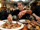 Anthony Bourdain digs in at Au Pied de Cochon during a four-day Montreal food blitz in 2004. His highest praise went to the foie gras poutine: 