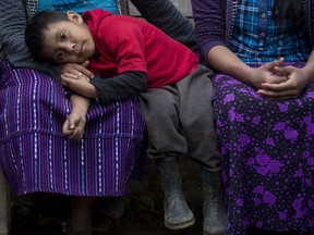 Six-year-old Mateo, the brother of Felipe Gomez Alonzo an 8-year-old Guatemalan boy who died in U.S. custody, rests his head on his mother's lap in their home in Yalambojoch, Guatemala, Saturday, Dec. 29, 2018. It was extreme poverty and lack of opportunity that drove Felipe's father, Agustin Gomez, and mother Catarina Alonzo to decide that he and the boy would set off for the United States.