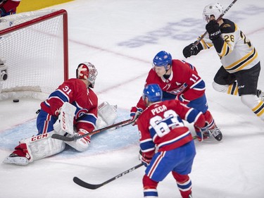 Boston Bruins centre Colby Cave scores ton Carey Price as Montreal Canadiens centre Matthew Peca (63) and teammate Brendan Gallagher look on during second period in Montreal  Monday, Dec. 17, 2018.