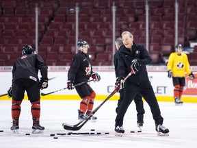 Canada's head coach Tim Hunter, front right, passes pucks during a drill during practice for the IIHF World Junior Hockey Championships, in Vancouver on Tuesday, Dec. 25, 2018. Canada is scheduled to play Denmark in their first game on Wednesday.