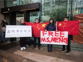 Supporters hold signs and Chinese flags outside B.C. Supreme Court during the third day of a bail hearing for Meng Wanzhou, the chief financial officer of Huawei Technologies, in Vancouver, on Tuesday December 11, 2018.