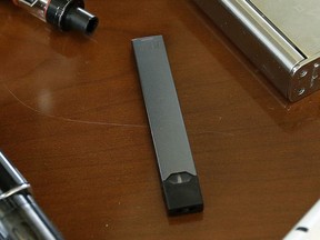 FILE - This April 10, 2018, file photo shows a Juul in Marshfield, Mass. Altria is spending $12.8 billion for a stake in e-vapor company JUUL as one of the world‚Äôs biggest tobacco companies tries to offset declining cigarette use.