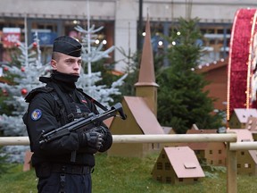 An armed policeman stands guard at Strasbourg's Christmas market, on its reopening day, one day after French police shot dead the gunman who killed three people there.
